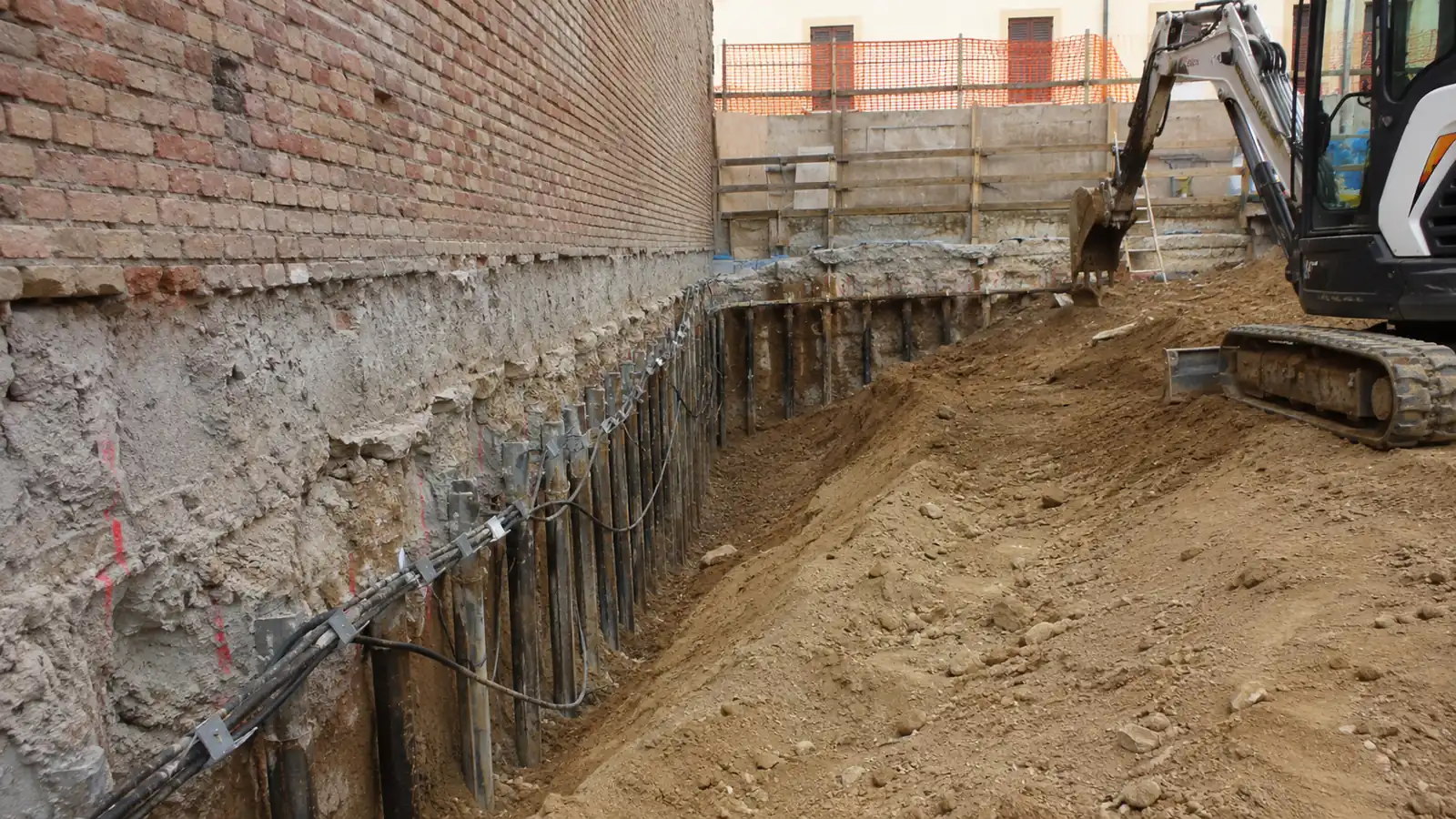 Scavo di fondazione aperto a ridosso del muro di confine, con paratia di micropali a sostegno del fronte