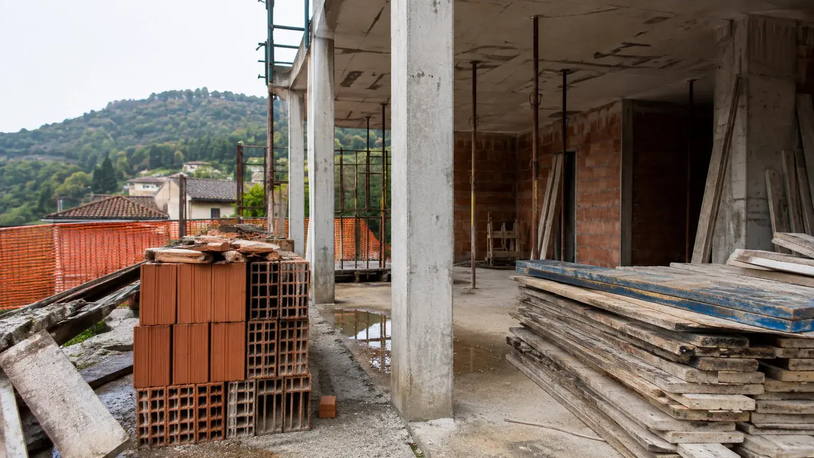 Cantiere con lavorazioni a metà e materiali accatastati, fermo