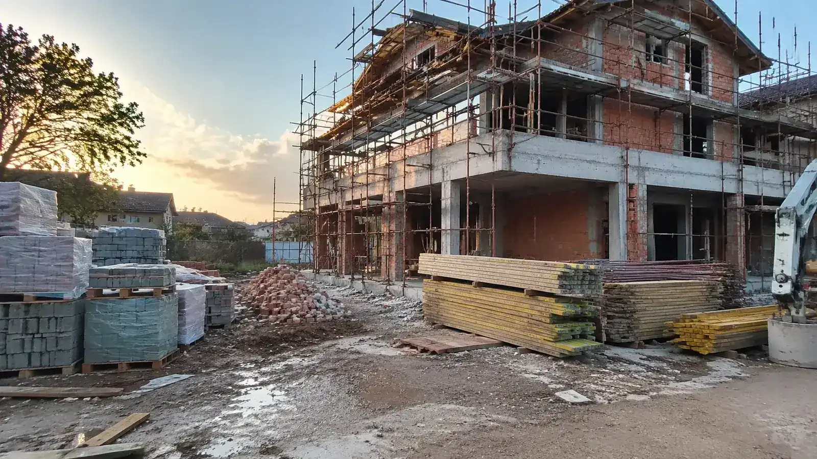 Cantiere con lavorazioni a metà e materiali accatastati, fermo